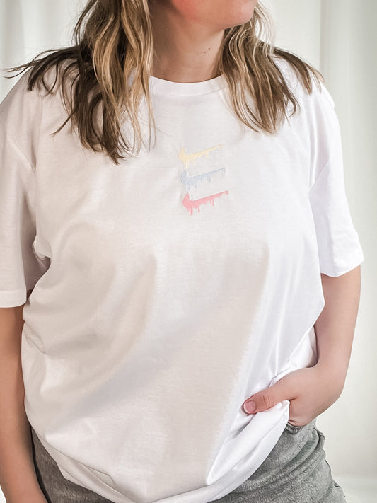 white t-shirt with pastel paint spill embroidered design out the purse